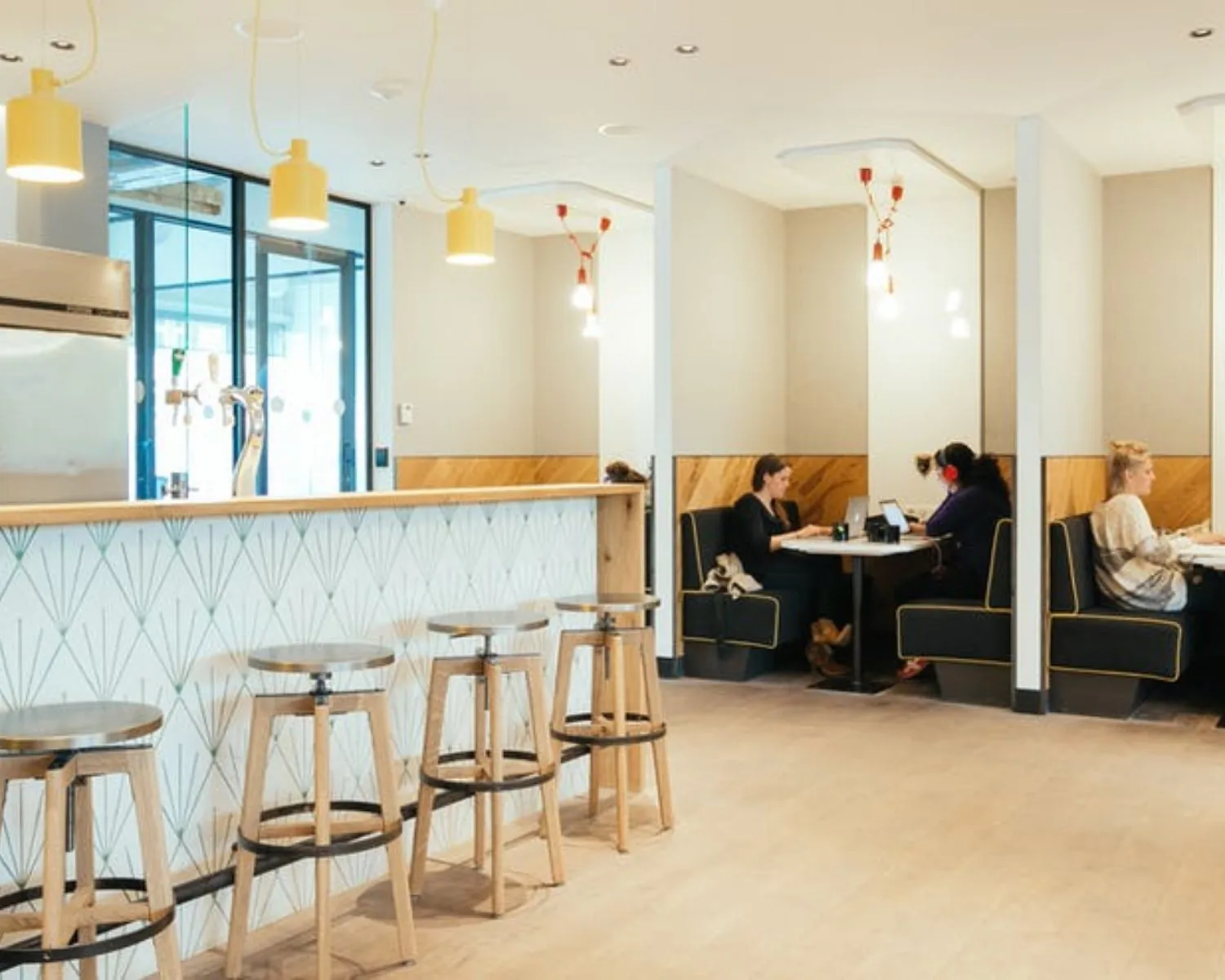 Moderne kantoorruimte aan de Weteringschans 165 met open zitplekken, bar met barkrukken en werkplekken in nisbanken.