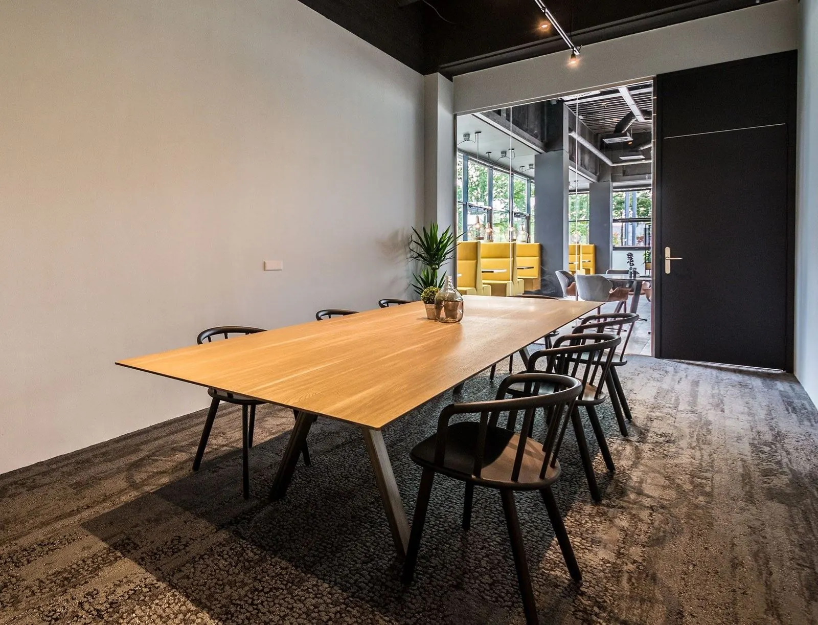 Vergaderruimte met houten tafel en zwarte stoelen in een modern kantoor aan de Heerbaan 14 in Breda.