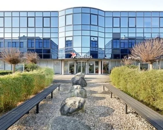 Moderne kantoorruimte te huur aan Elisabethhof 21-23 met glazen gevel en verzorgde tuin met zitbanken.