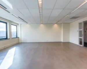 Lege kantoorruimte met grote ramen en systeemplafond aan de Mollerusweg 84.