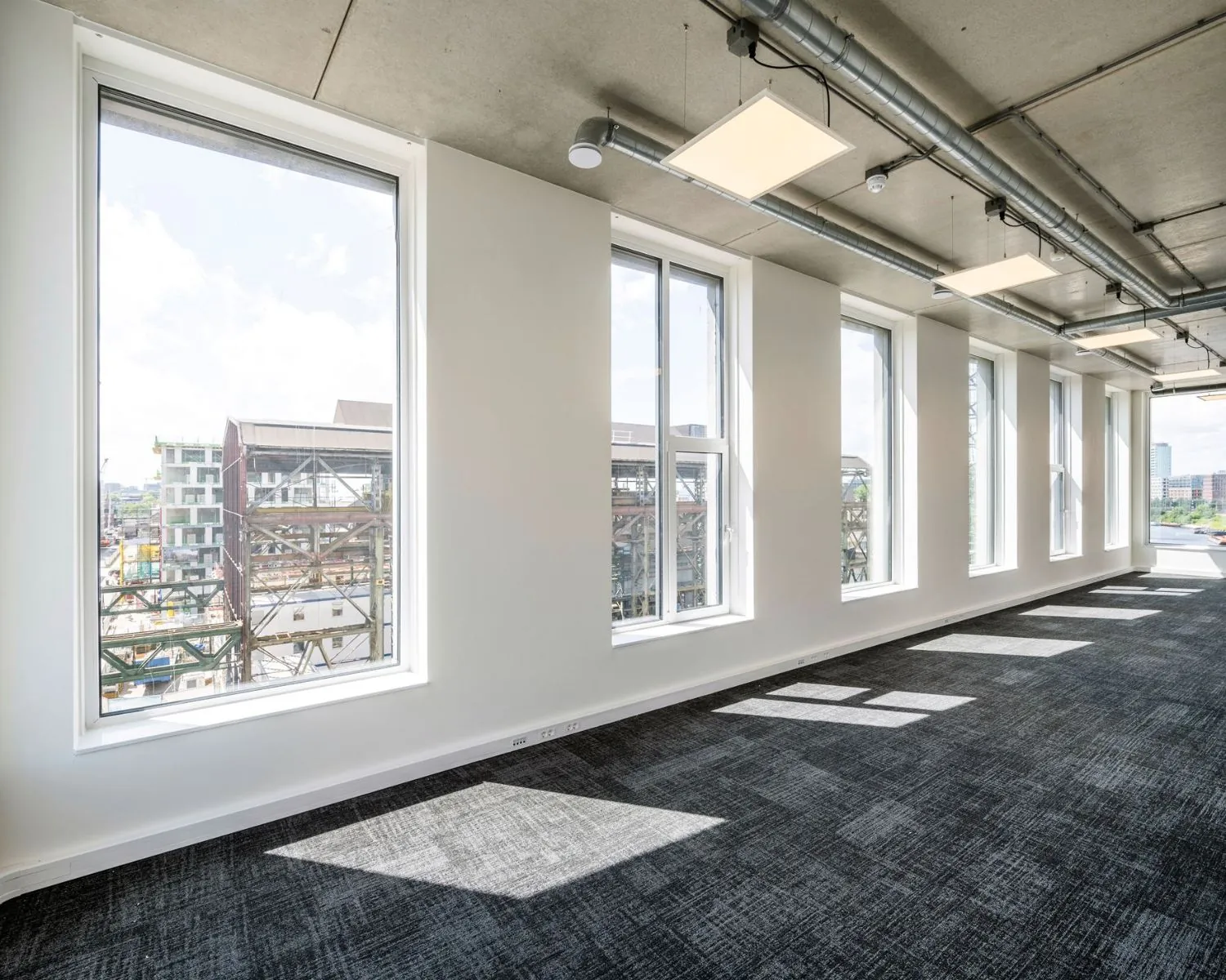 Lichte, moderne kantoorruimte met grote ramen aan de Oostenburgermiddagstraat in Amsterdam.