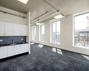 Lichte, moderne kantoorruimte met grote ramen en een ingebouwde kitchenette aan de Oostenburgermiddagstraat 601.