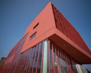 Modern rood kantoorgebouw aan de Panamalaan met grote ramen en een opvallend hoekig ontwerp.