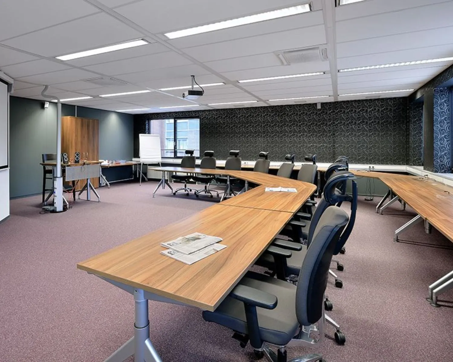 Moderne vergaderruimte met U-vormige opstelling, bureaustoelen en presentatiefaciliteiten aan de Pascalstraat 15.