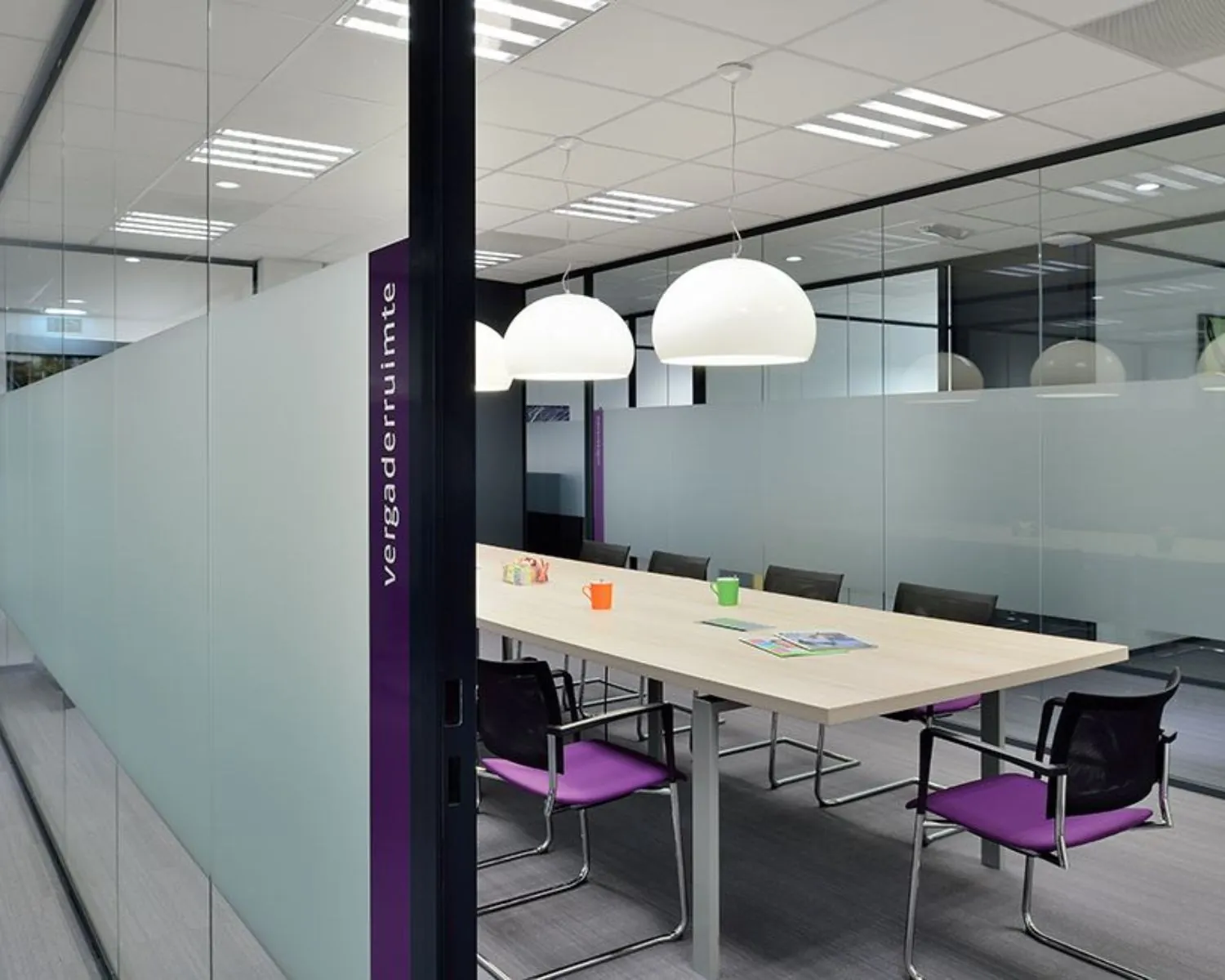 Moderne vergaderruimte met glazen wanden en een lange tafel in een kantoorruimte aan de Pascalstraat 15.