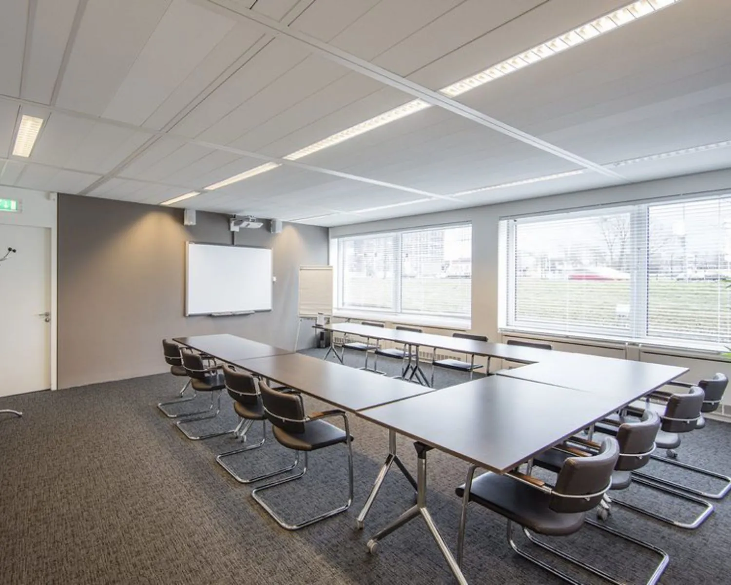 Moderne vergaderruimte met U-vormige opstelling en grote ramen in een kantoorgebouw aan de Polarisavenue 1 in Hoofddorp.