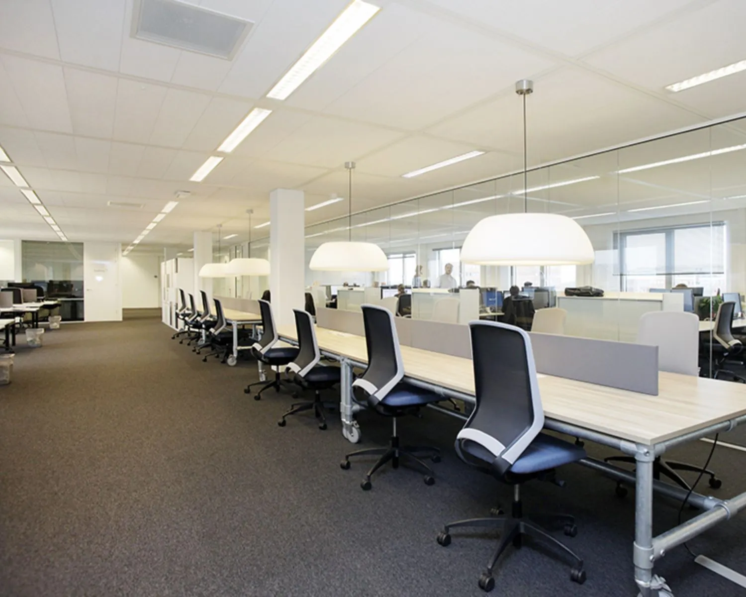 Moderne open kantoorruimte met bureaus en bureaustoelen aan de Polarisavenue 1 in Hoofddorp.