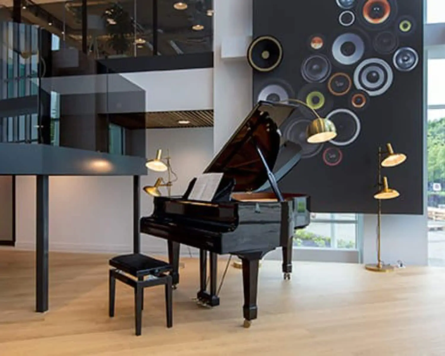 Moderne kantoorruimte aan de Saturnusstraat 46 in Hoofddorp met een vleugel, designverlichting en een opvallende wanddecoratie met luidsprekerontwerp.