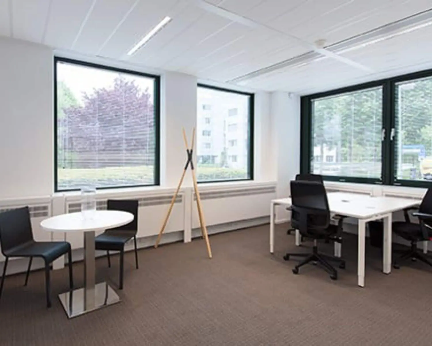 Moderne, lichte kantoorruimte met bureaus, stoelen en grote ramen aan de Saturnusstraat 46 in Hoofddorp.