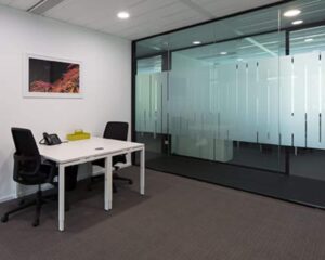 Moderne kantoorruimte met twee bureaustoelen, een wit bureau en glazen scheidingswand aan de Saturnusstraat 46 in Hoofddorp.