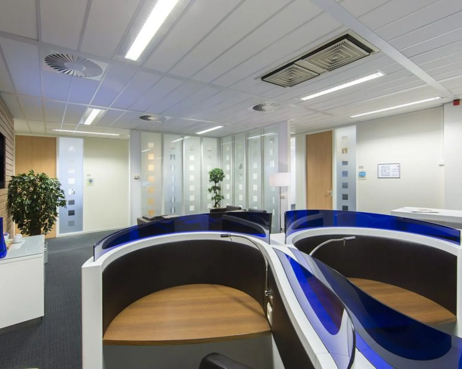 Moderne kantoorruimte met ronde werkplekken en glazen scheidingswanden aan de Siriusdreef 17 in Hoofddorp.