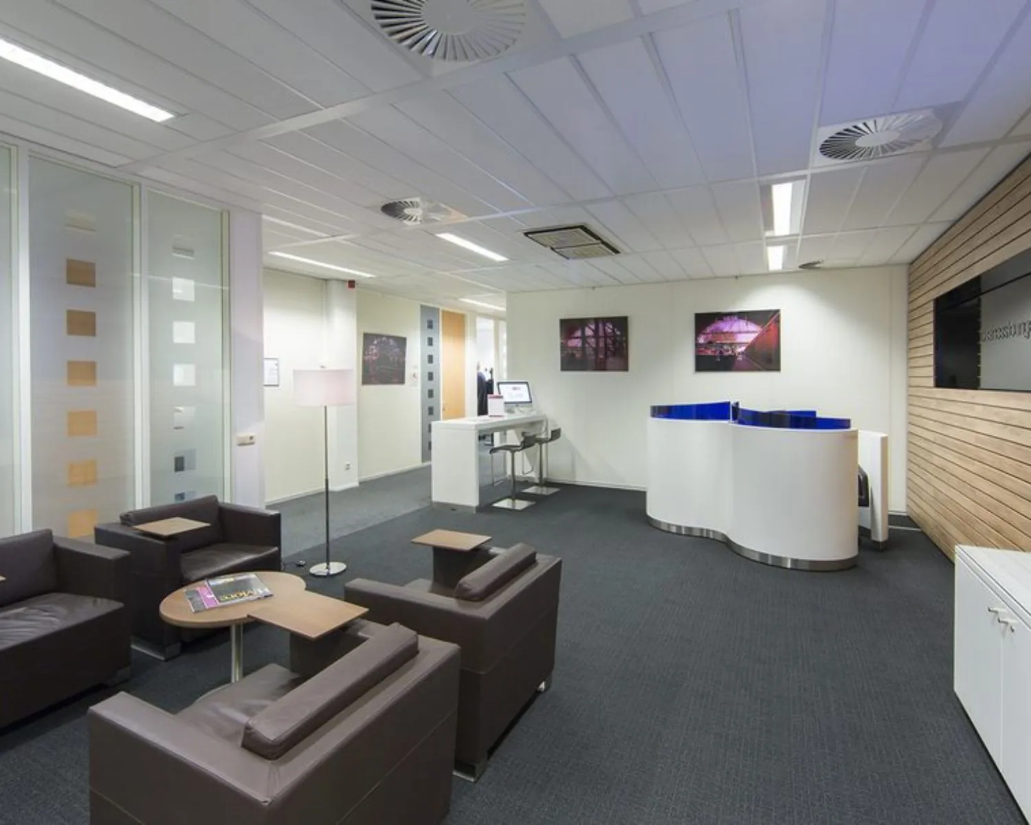 Moderne ontvangstruimte met zithoek, balie en werkplekken in kantoor aan de Siriusdreef 17 in Hoofddorp.