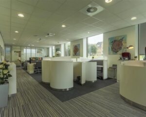 Moderne kantoorruimte met afgeronde werkplekken en grote ramen aan het Stationsplein 8-18.