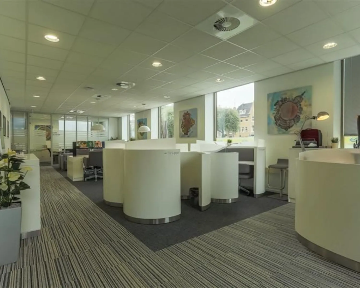 Moderne kantoorruimte met afgeronde werkplekken en grote ramen aan het Stationsplein 8-18.