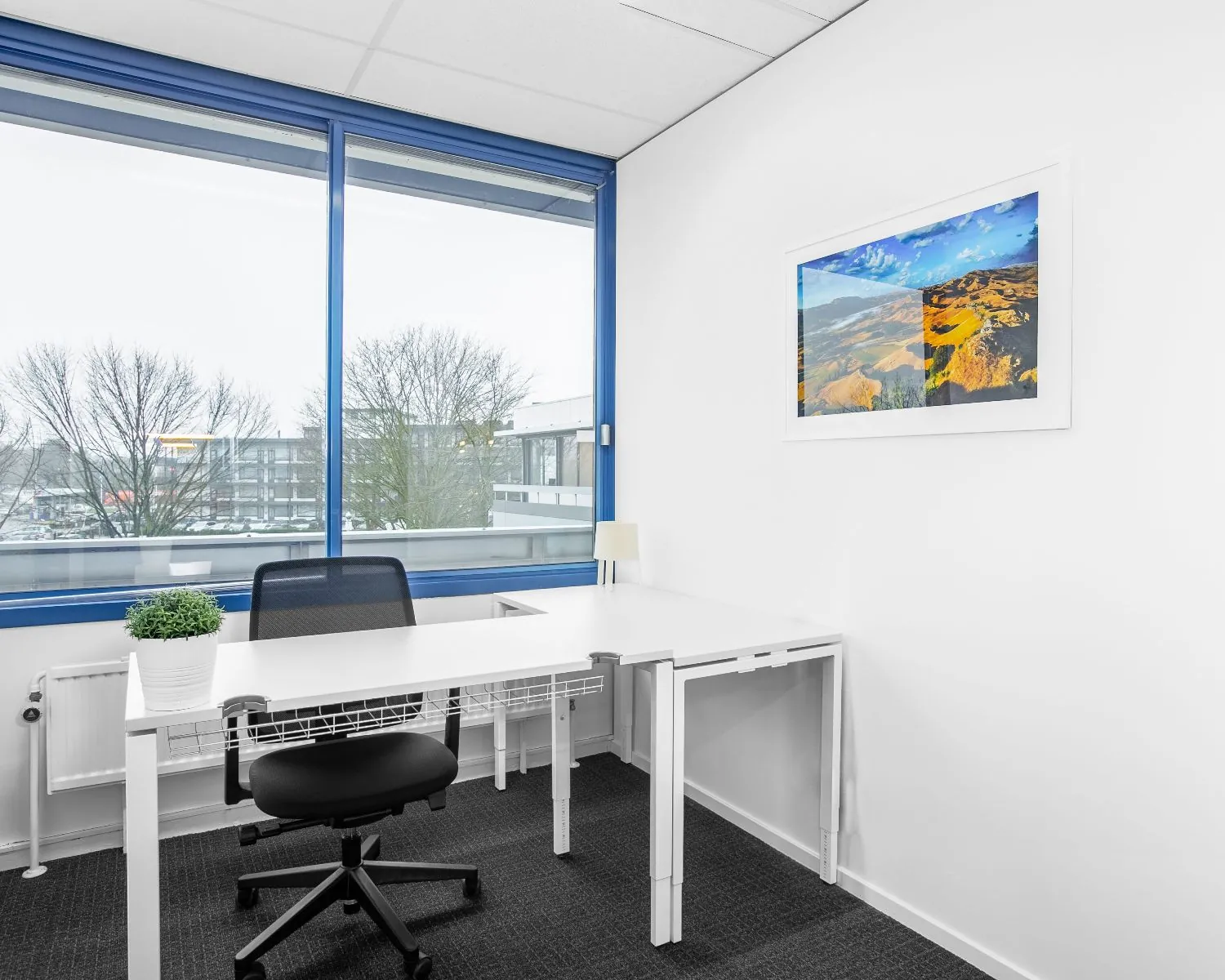 Moderne, lichte kantoorruimte met bureau, bureaustoel en groot raam aan de Laan van Westroijen 6 in Tiel.