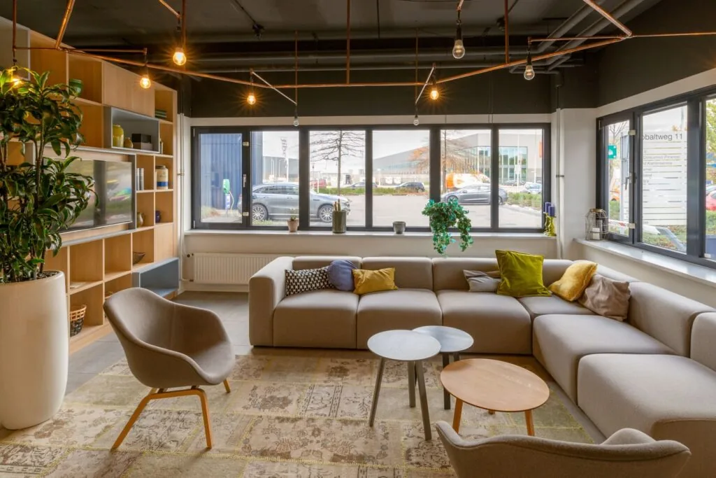 Moderne en sfeervolle loungehoek met zitbanken en designstoelen in een kantoorruimte aan de Kobaltweg 11.