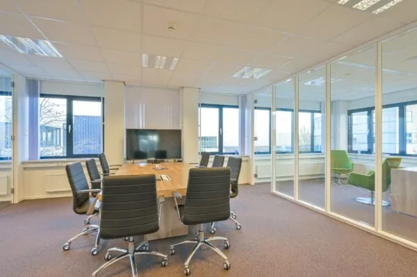 Moderne vergaderruimte met glazen wanden en grote ramen in kantoorruimte aan de Kobaltweg 11.