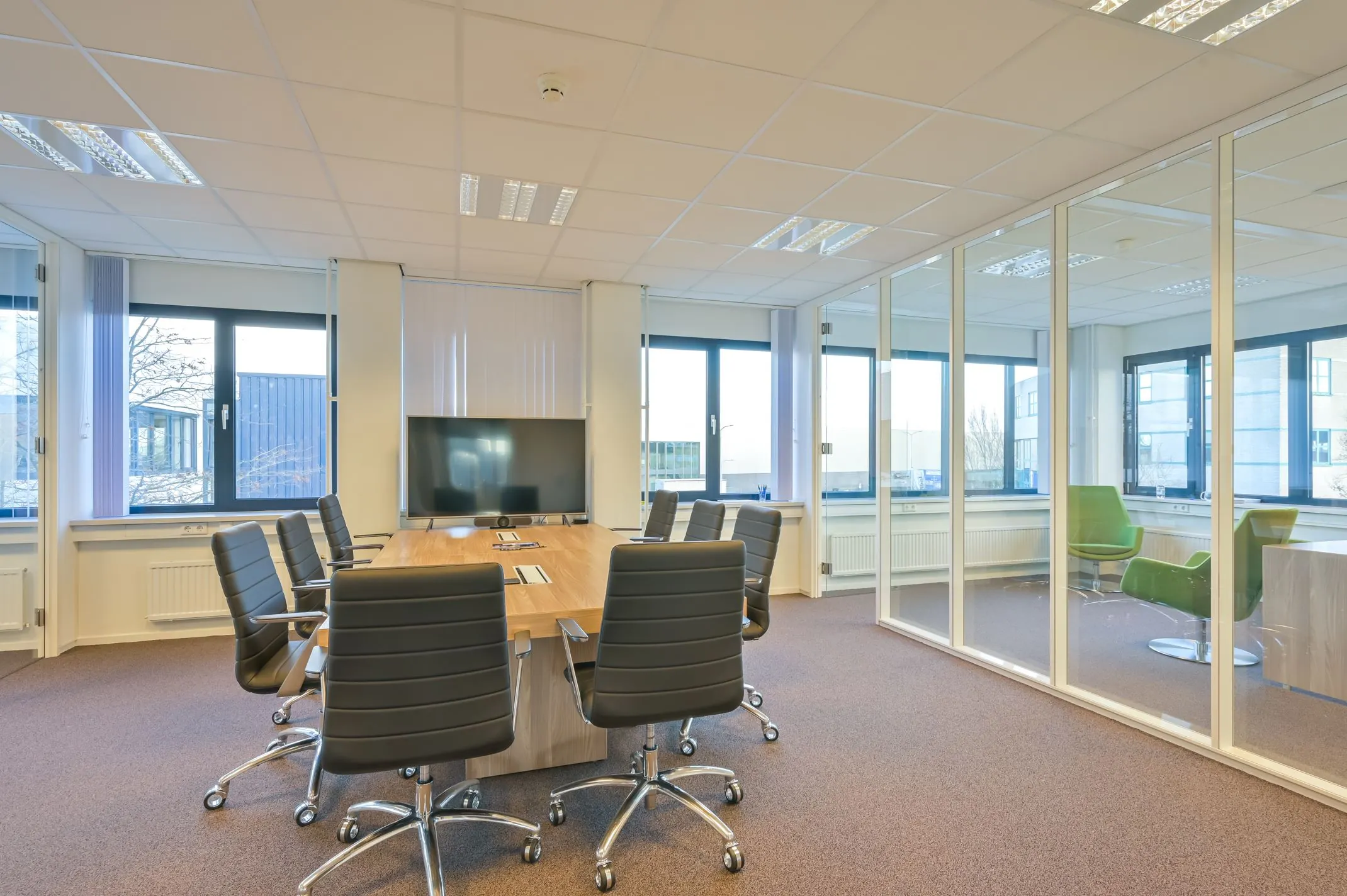 Moderne vergaderruimte met glazen wanden en grote ramen in kantoorruimte aan de Kobaltweg 11.