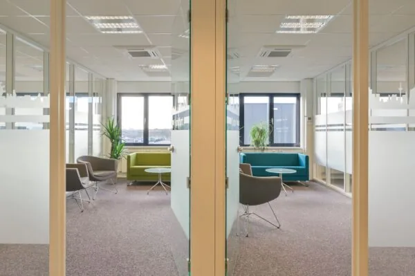 Moderne kantoorruimte aan de Kobaltweg 11-5 met glazen wanden, zitgedeelte en veel daglicht.
