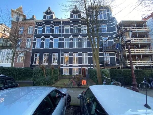 Gevelaanzicht van een karakteristiek kantoorpand aan de Sophialaan 21 in Amsterdam met geparkeerde auto’s en fietsen op de voorgrond.