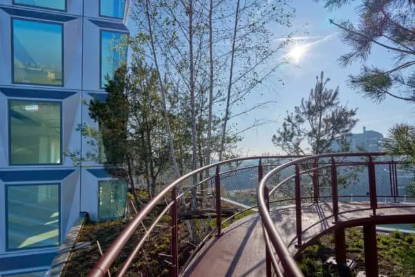 Modern kantoorgebouw aan de Hildegard von Bingenstraat 44 in Amsterdam met een verhoogd wandelpad en groenvoorziening op het dakterras.