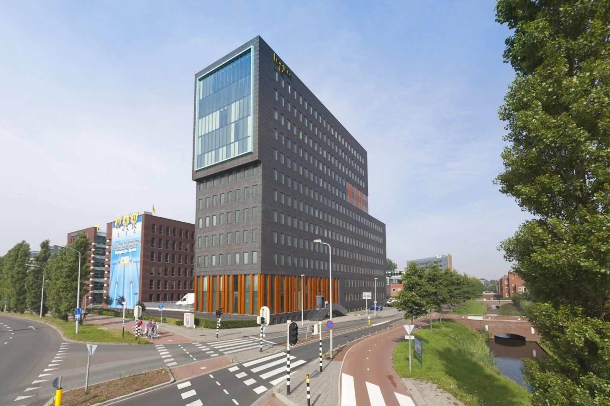 Modern kantoorgebouw in Rijswijk gelegen aan een kruispunt met fietspad en groenstrook.