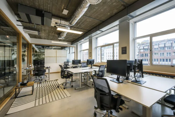Moderne kantoorruimte met werkplekken, bureaustoelen en grote ramen aan de Singel 542 in Amsterdam.
