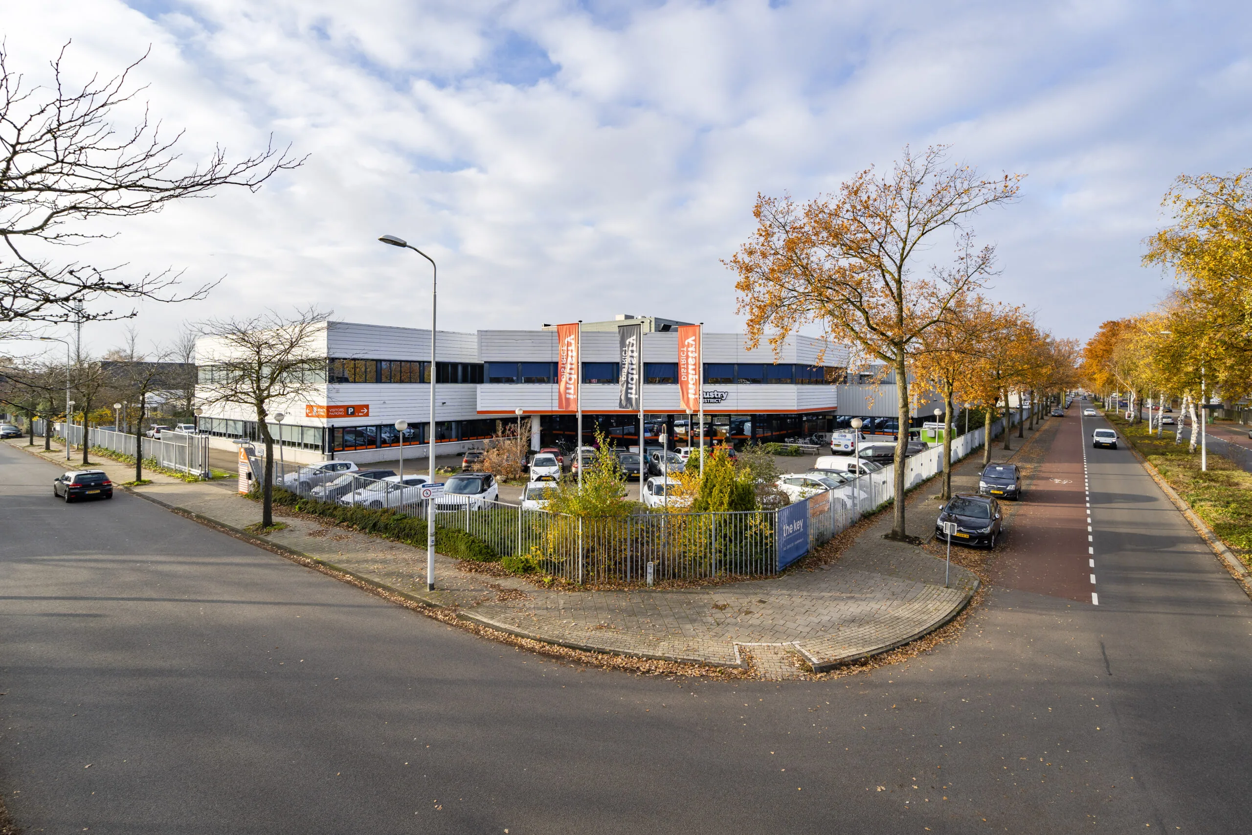 Bedrijfsverzamelgebouw met parkeerterrein aan de Tarasconweg 2 in Eindhoven, gefotografeerd vanaf de straat.