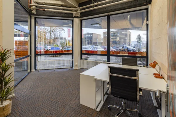 Moderne kantoorruimte met twee bureaus en grote ramen aan de Tarasconweg 2 in Eindhoven.