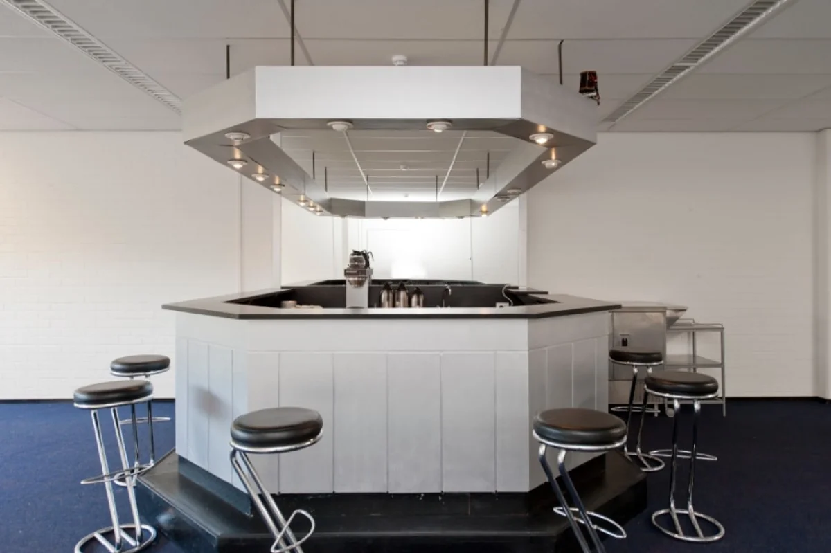 Moderne kantoorkeuken met een zeshoekige bar en barkrukken in een ruimte aan de Markerkant 13-70 in Almere.
