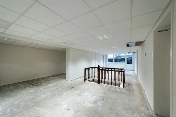 Lege kantoorruimte met open trap en grote ramen aan de Jan Luijkenstraat 92 in Amsterdam.