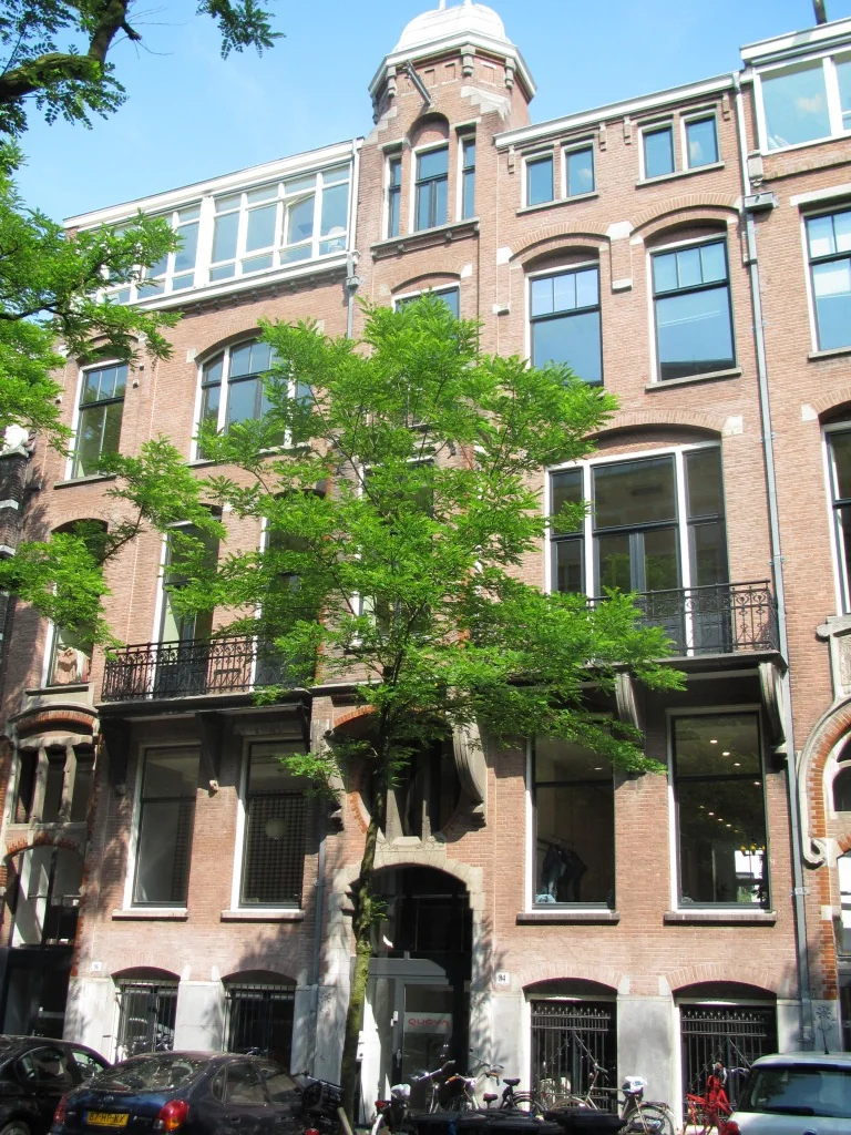 Voorgevel van een gerenoveerd historisch kantoorpand aan de Jan Luijkenstraat 92 in Amsterdam, met grote ramen en een centraal geplaatste boom.