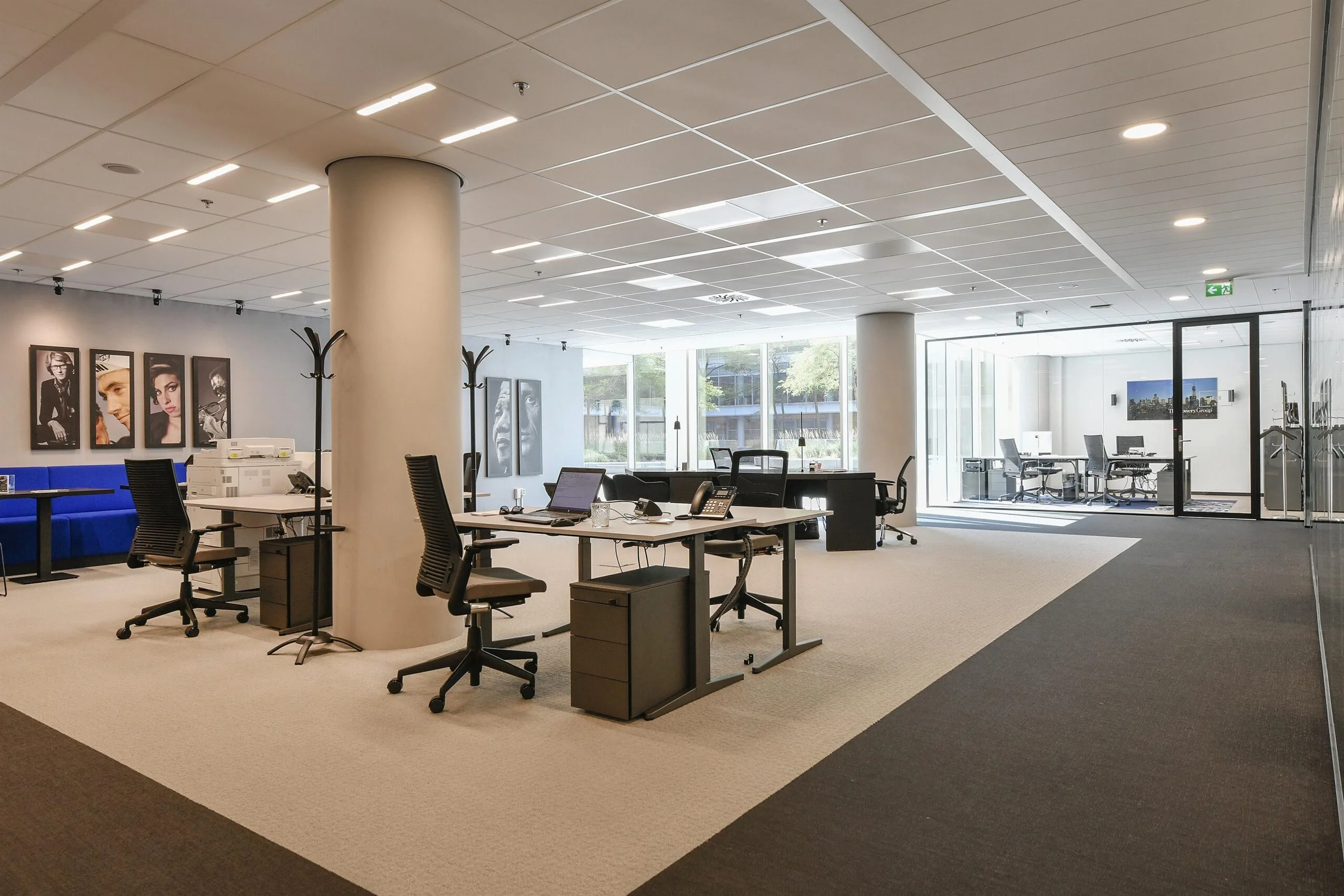 Moderne, lichte kantoorruimte in Amsterdam Zuidas met open werkplekken, vergaderruimte en kunst aan de muur.