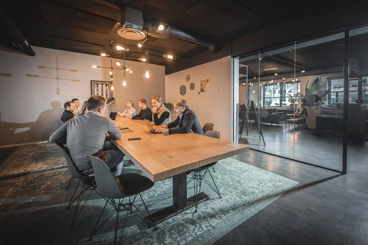 Moderne vergaderruimte met houten tafel en glazen wand in kantoor aan de Brugstraat 11 in Almelo.