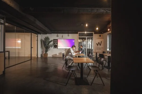 Moderne kantoorruimte aan de Brugstraat 11 in Almelo met twee personen werkend aan een tafel in een open, sfeervol ingerichte ruimte.