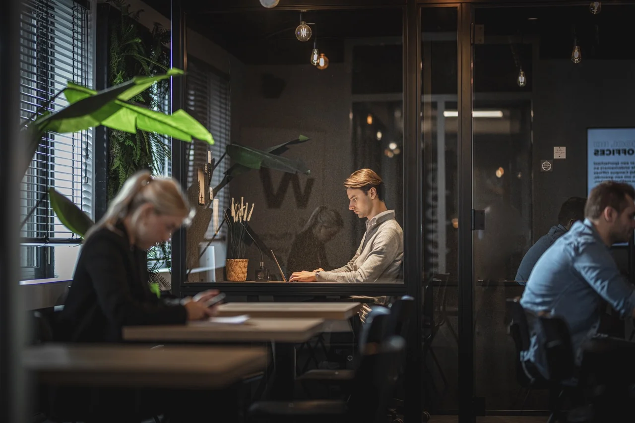 Moderne kantoorruimte aan de Brugstraat 11 in Almelo met werkplekken in een glazen vergaderruimte en open werkruimte.