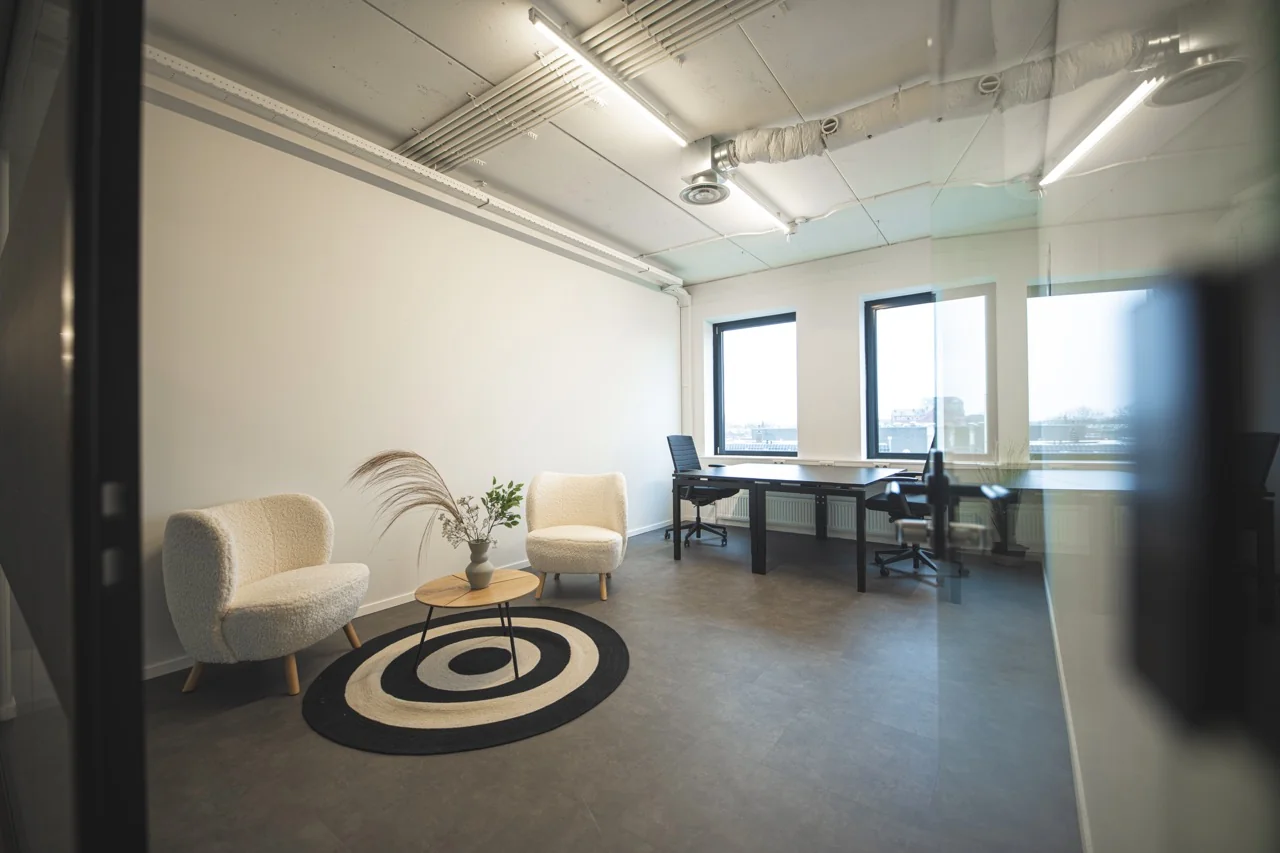 Moderne kantoorruimte aan de Brugstraat 11 in Almelo met zithoek, werkplekken en grote ramen.