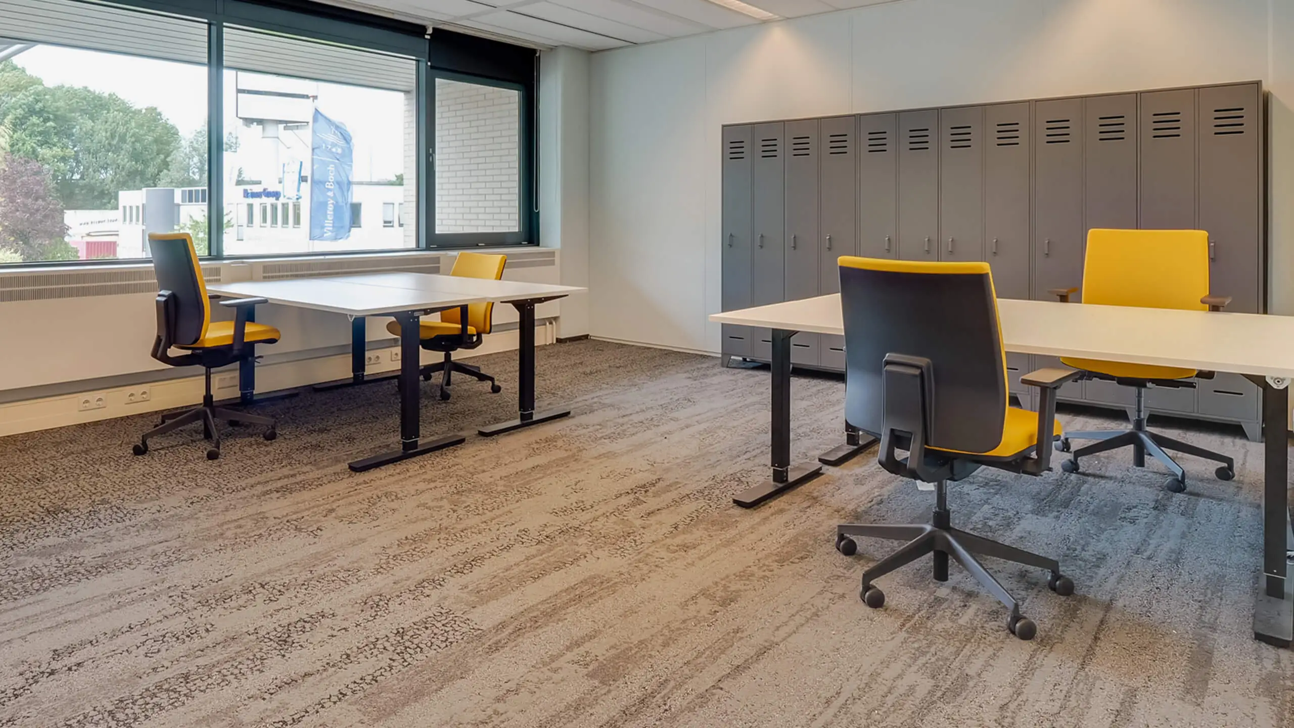 Moderne kantoorruimte aan de Bruistensingel 400 in Den Bosch met werkplekken, gele bureaustoelen en grijze lockerkasten.