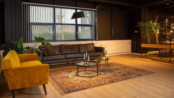 Stijlvol ingerichte kantoorruimte aan de Bruistensingel 400 in Den Bosch met zithoek, vintage vloerkleed en moderne decoratie.