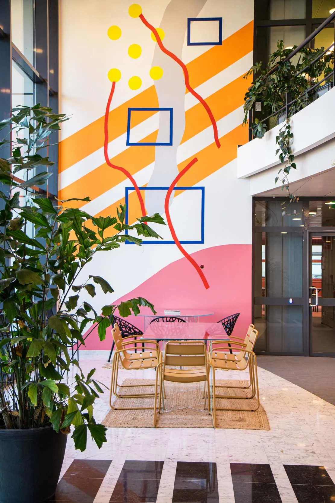 Moderne kantoorruimte aan de Bruistensingel 500 in Den Bosch met kleurrijke wandkunst, glazen vergadertafel en omringend groen.