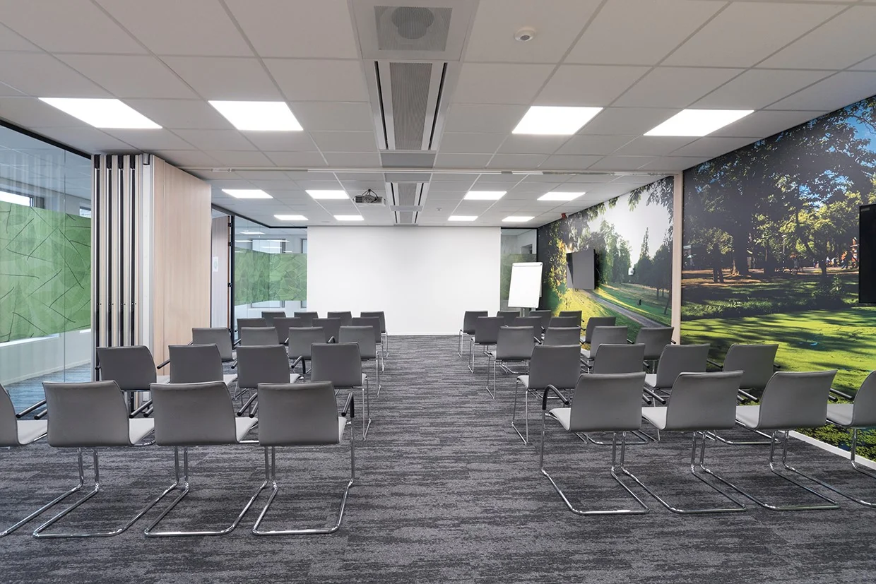 Moderne vergaderruimte met opstelling van grijze stoelen en natuurprint op de wand in Handelsplein 59, Amstelveen.