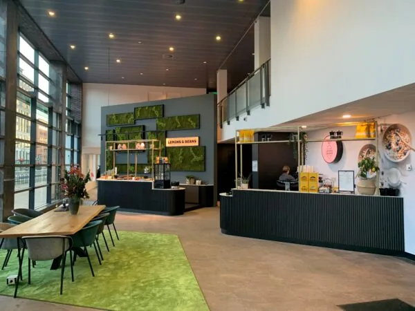 Moderne entree van kantoorruimte aan Handelsplein 59 in Amstelveen met koffiebar Lemons & Beans en zitgedeelte.