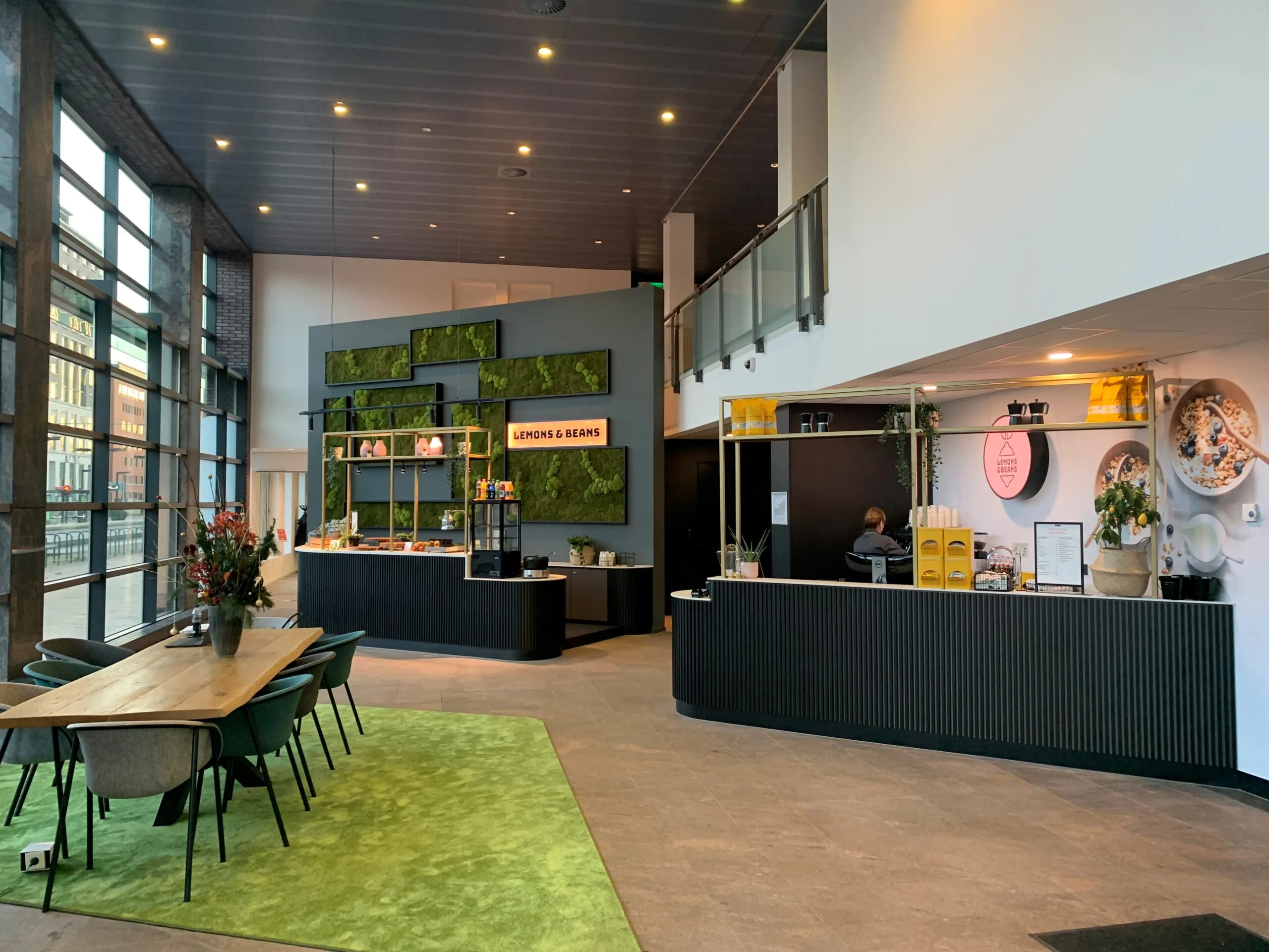 Moderne entree van kantoorruimte aan Handelsplein 59 in Amstelveen met koffiebar Lemons & Beans en zitgedeelte.