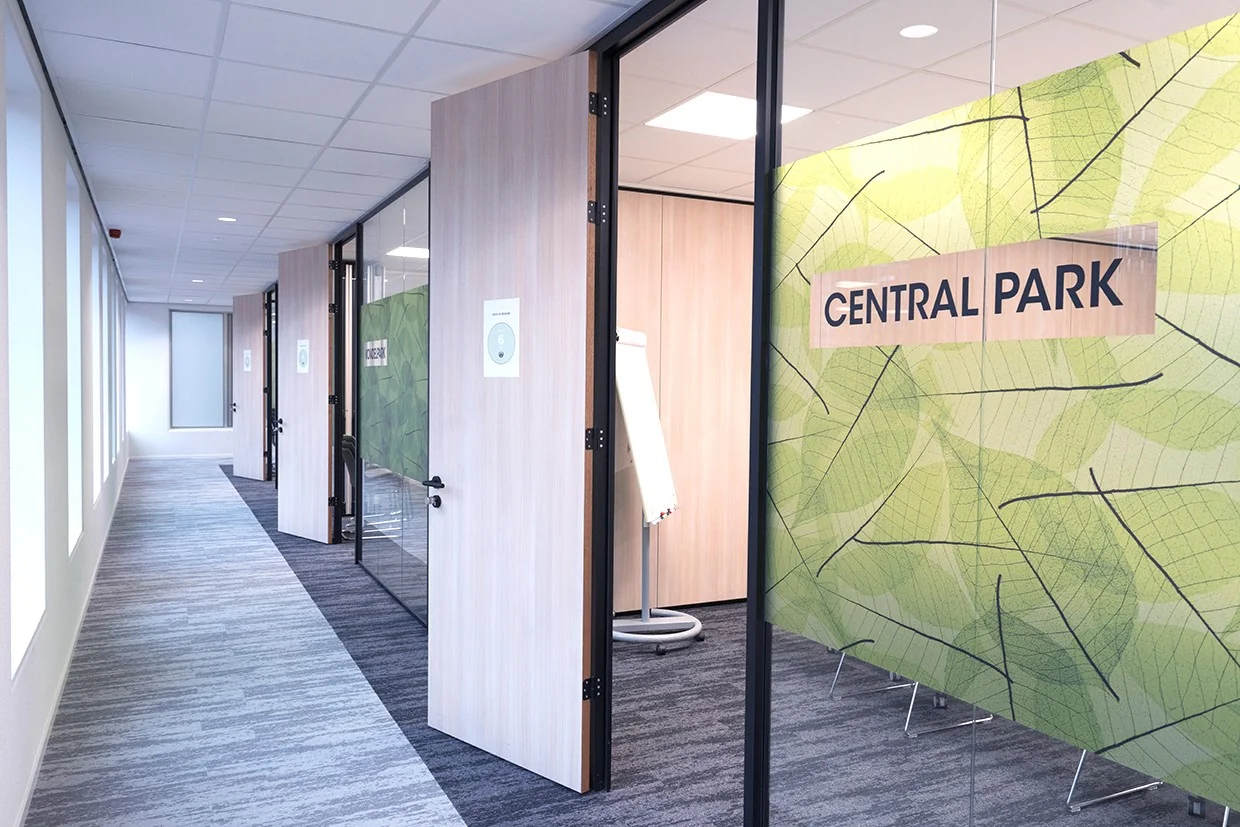 Moderne kantoorruimte aan Handelsplein 59 in Amstelveen met glazen wanden en de naam "Central Park" op een groene wand.
