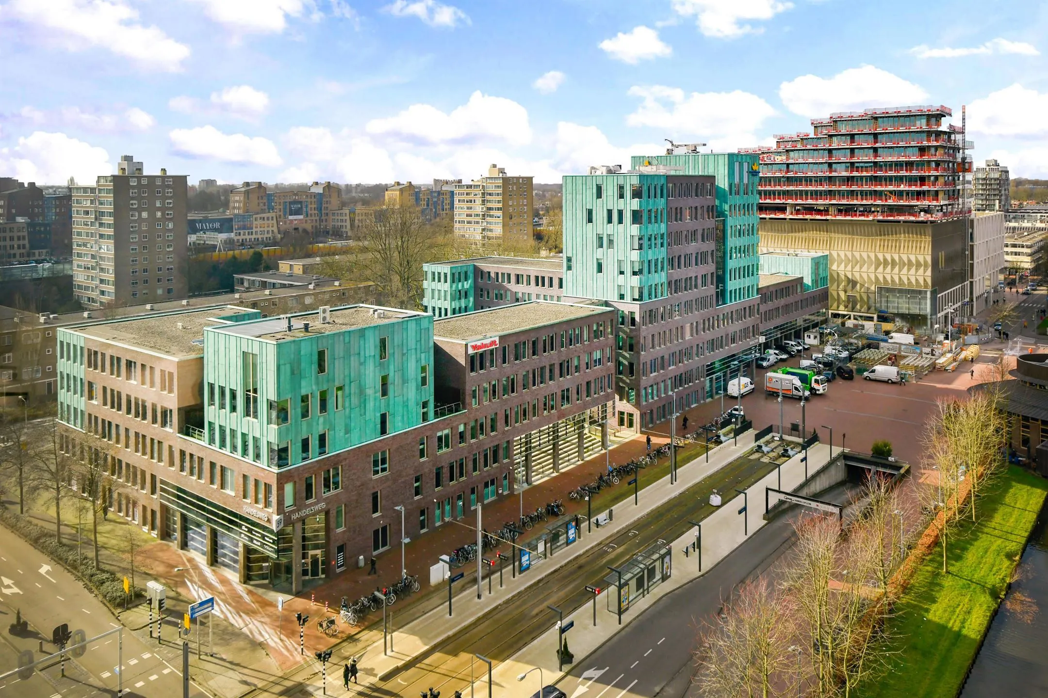 Moderne kantoorgebouwen aan de Handelsweg 59 in Amstelveen, met trambaan en stadsverkeer op de voorgrond.