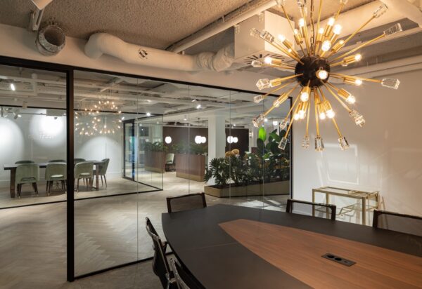 Moderne kantoorruimte in Hoofddorp met glazen wanden, sfeervolle verlichting en stijlvolle vergadertafels.