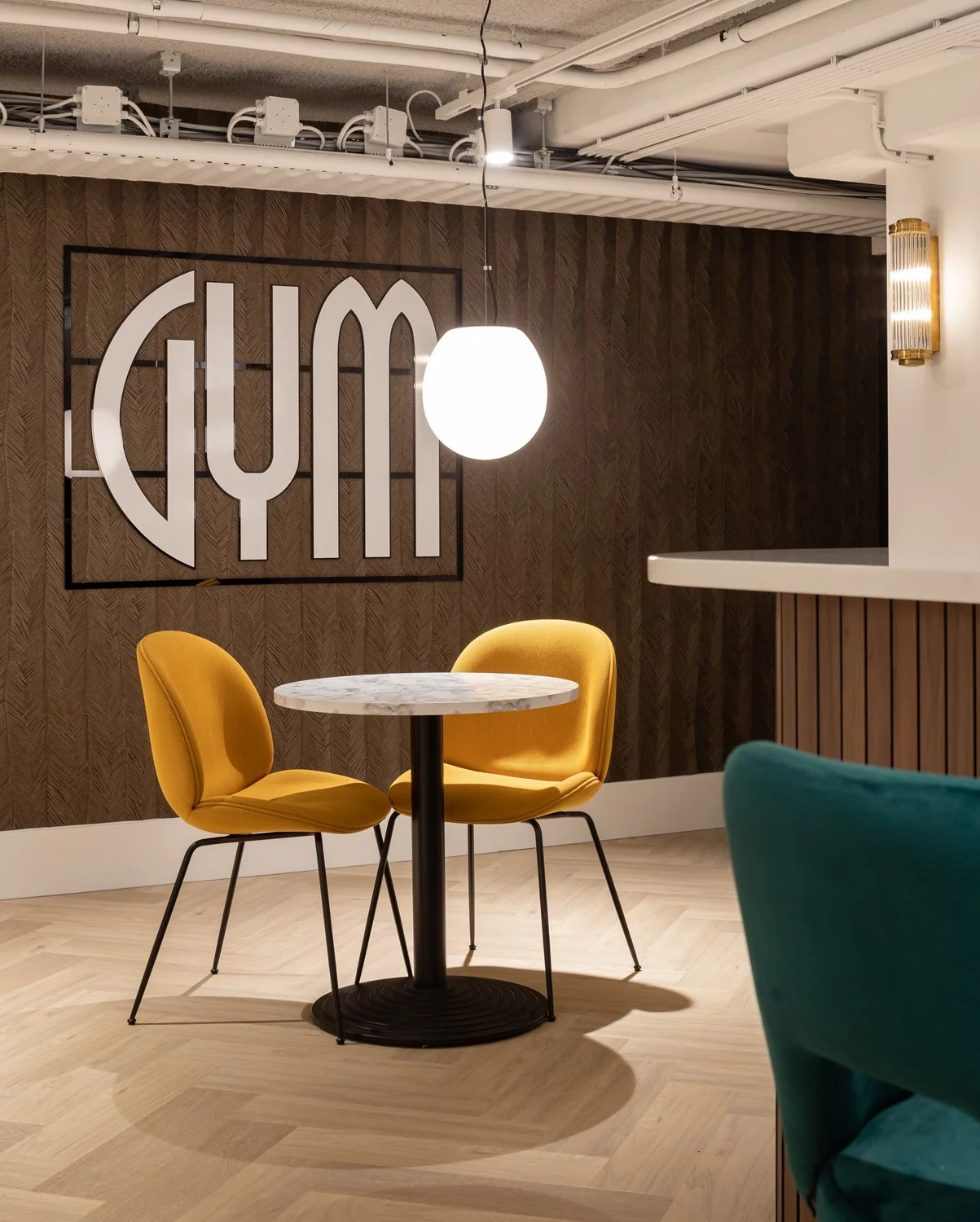 Moderne kantoorruimte in Hoofddorp met een stijlvol zitgedeelte en decoratieve wand met het woord 'GYM'.