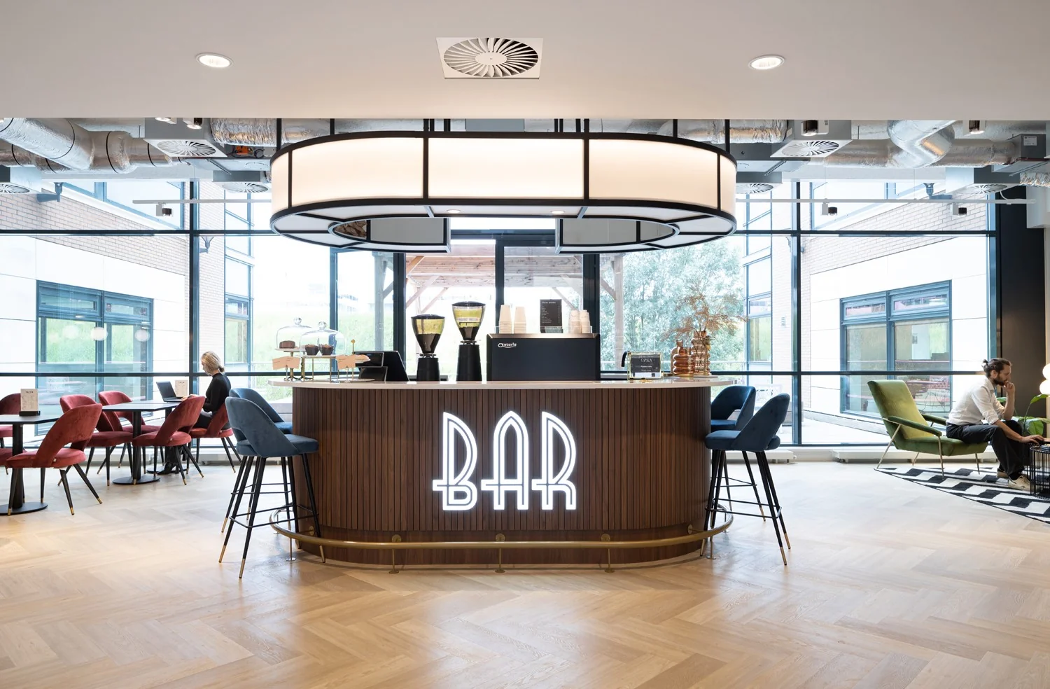 Moderne koffiebar in een lichte kantoorruimte in Hoofddorp met zitjes en werkplekken.