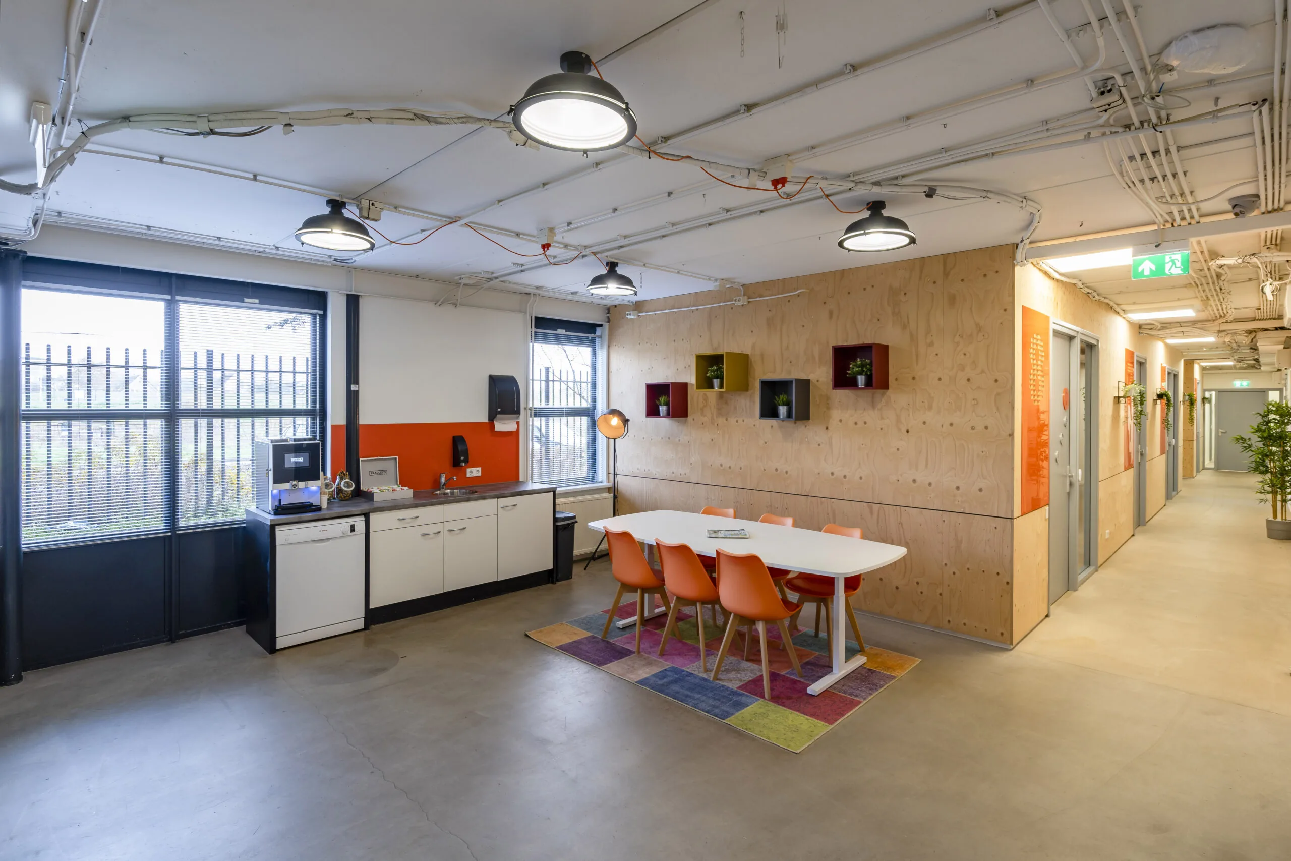 Moderne gedeelde kantoorruimte in Hoofdveste 2 in Houten met vergadertafel, kitchenette en kleurrijke accenten.