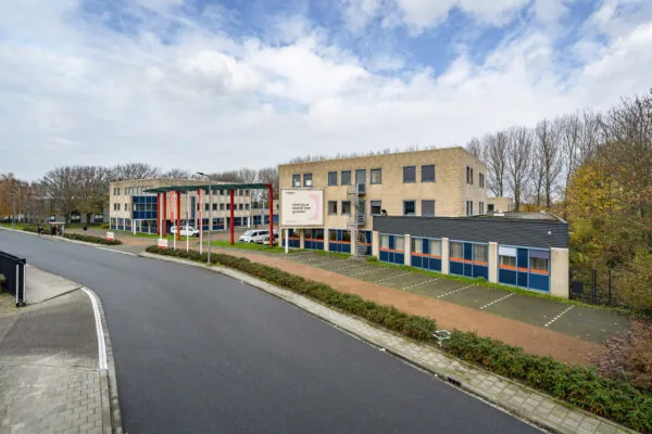 Kantoorcomplex aan de Innsbruckweg 103 in Rotterdam met parkeerplaatsen en omliggend groen.